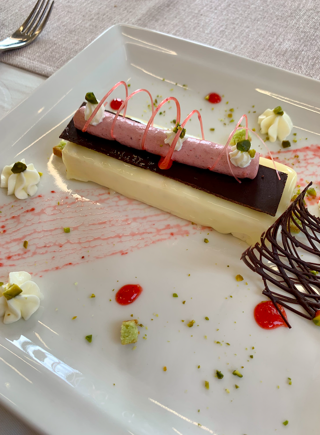 Fancy French dessert on a white plate prepared by a culinary student in France.