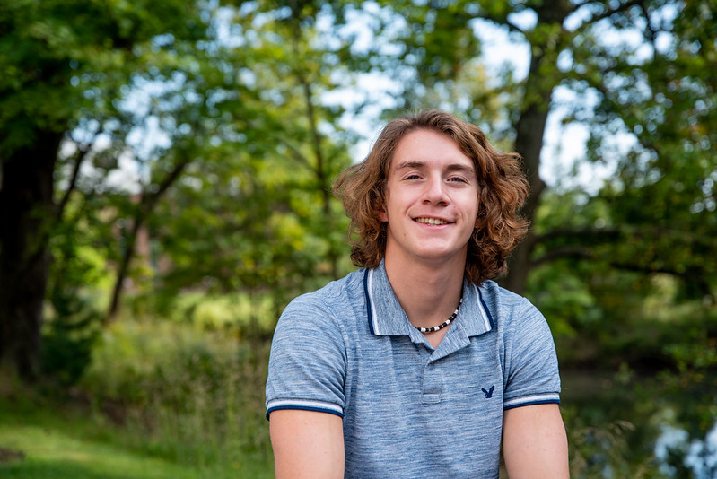 Nick poses in front of some trees.