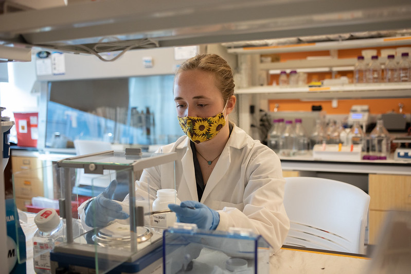 Katie performs an experiment in a lab.