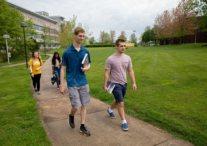 Students walk with textbooks on campus.
