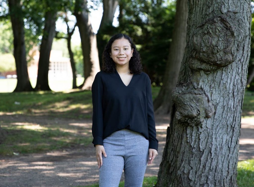 Erika poses next to a tree.