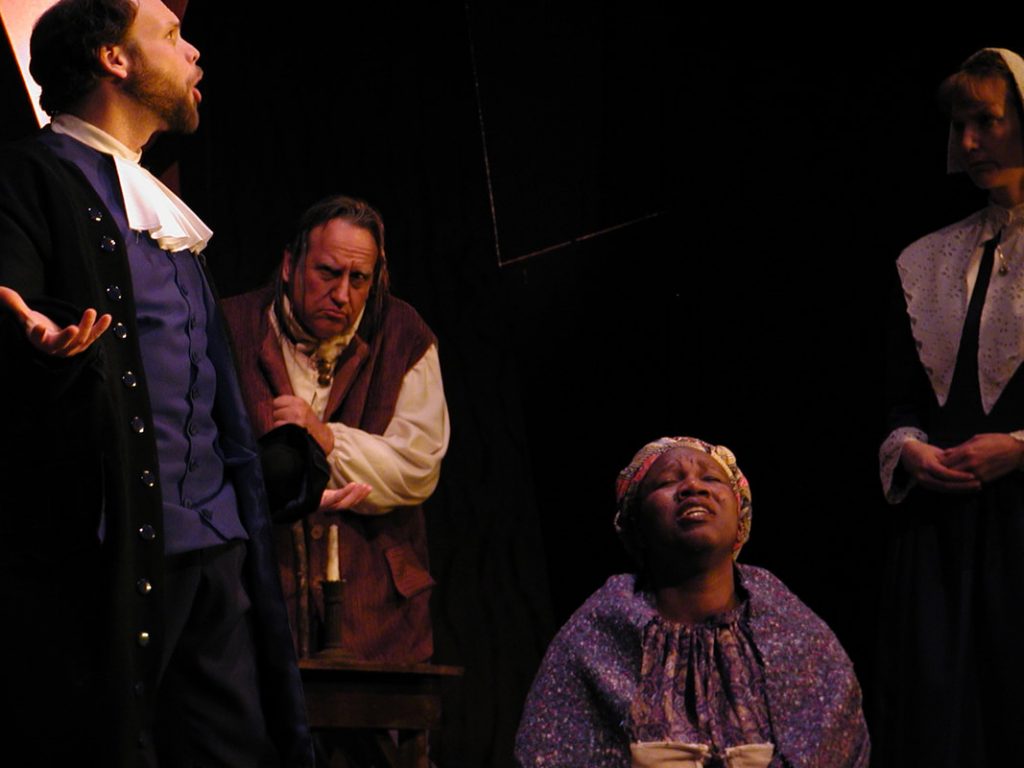 Felicia performing on stage during a theatre production surrounded by three other actors
