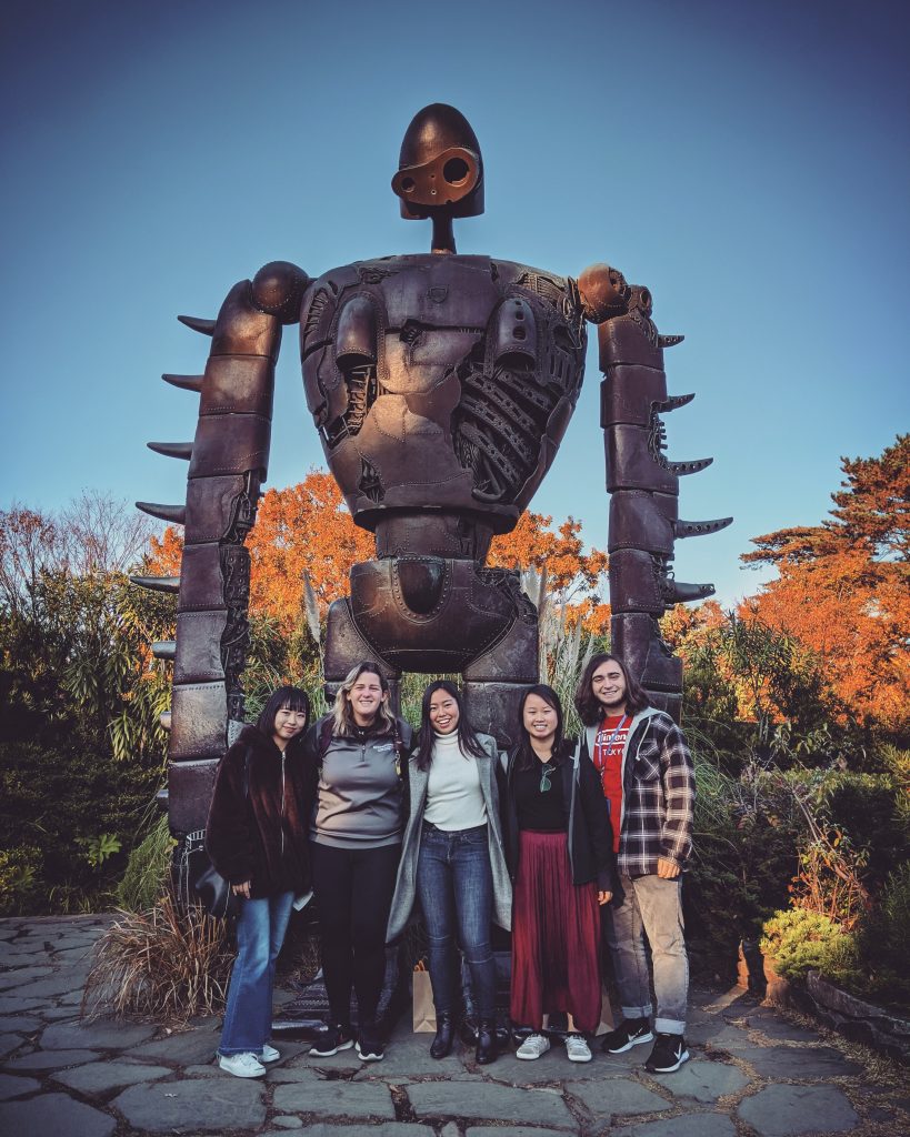 Dominique and her friends in front of a futuristic statue in Japan. 