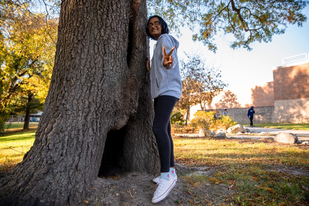 Mita poses next to a tree on campus.