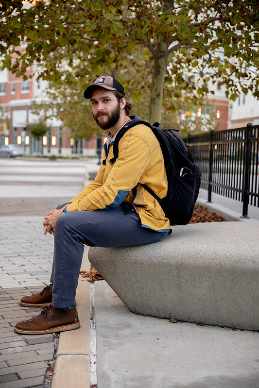 Alex sits on a concrete bench on Rowan Boulevard.