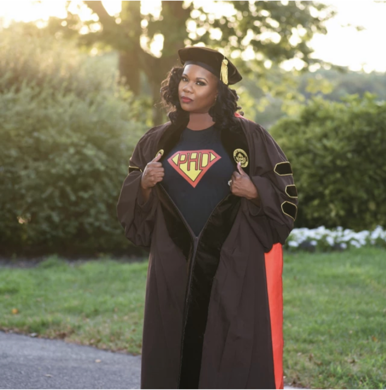 Janelle in her doctoral regalia with Ph.D superman shirt.
