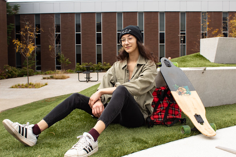 Maria posing next to her longboard in front of Wilson Hall.