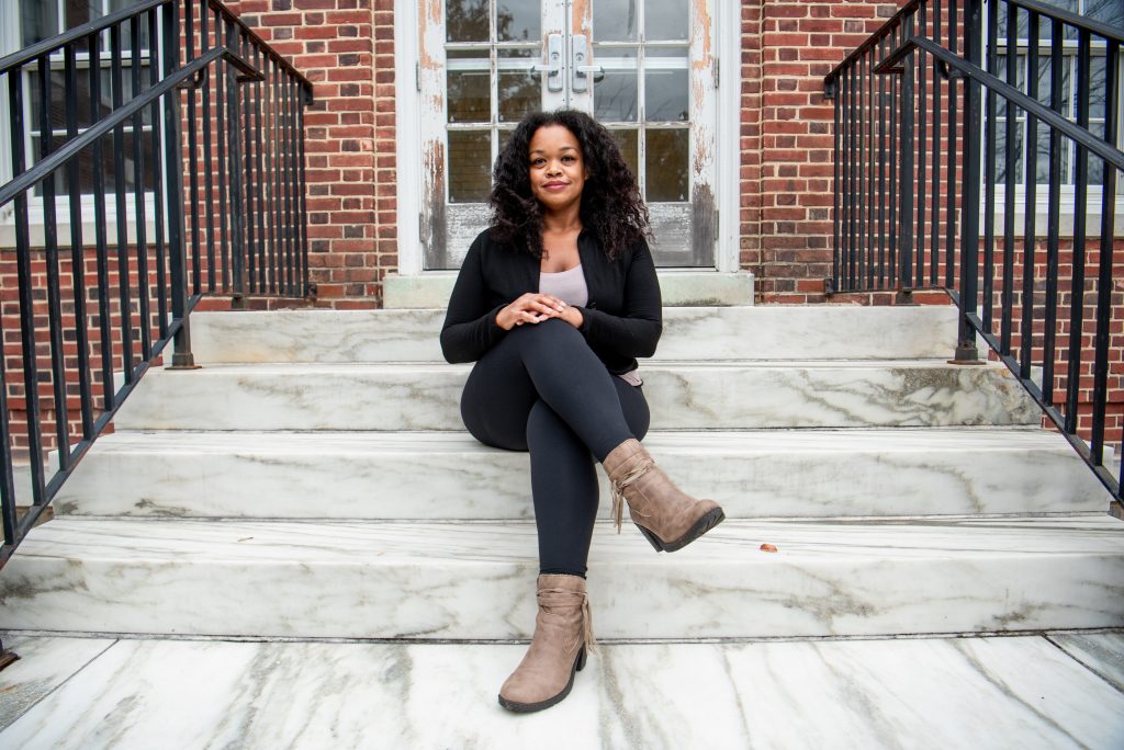 Psychology major Mel poses on the steps of Bunce Hall.