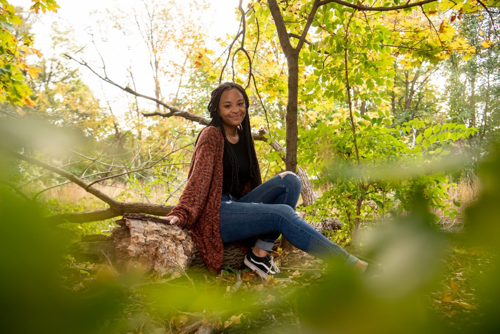 Samaria poses in the woods on campus.