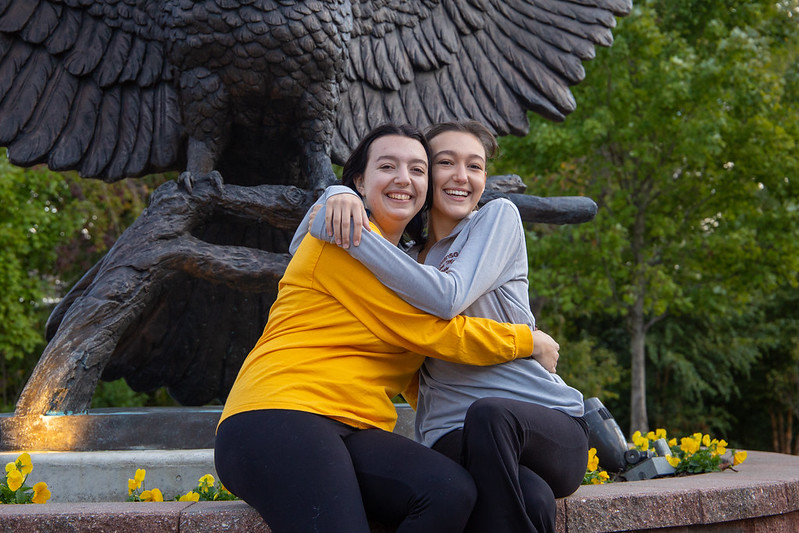 Sarah and Madeline McClure hug at the Rowan Prof statue.