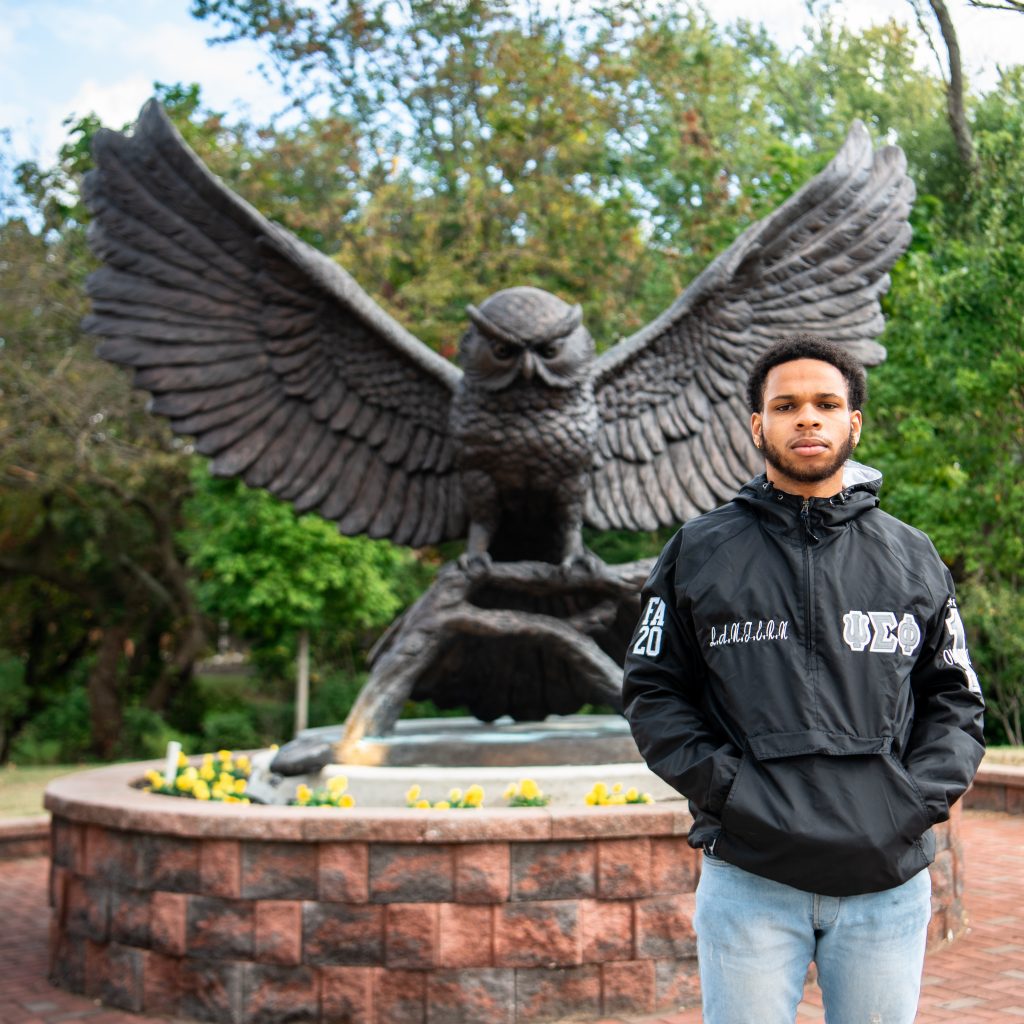 Zyaire poses next to the Prof statue.
