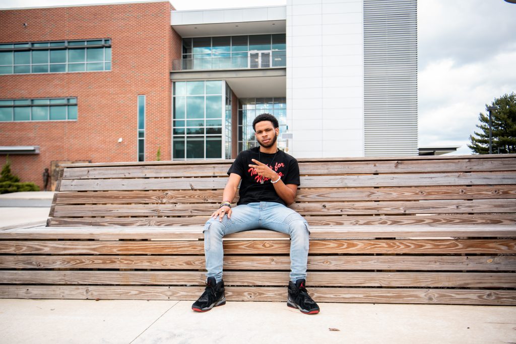 Zyaire sits on a bench outside James Hall.
