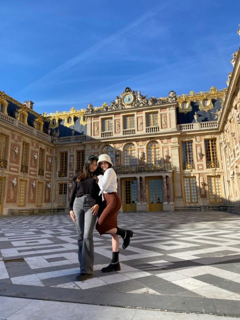 A picture of Calysta (left) with friend (Nadia) in front of Musée à Versailles in France. 