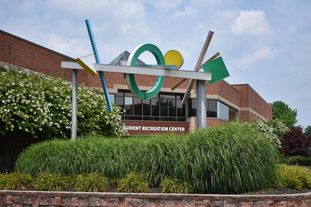 External shot of the Student Recreation Center building with public art in the foreground.