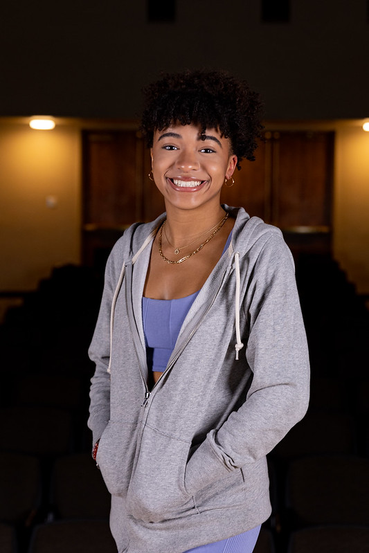 Vertical portrait of Gabrielle with her hands in her sweatshirt.