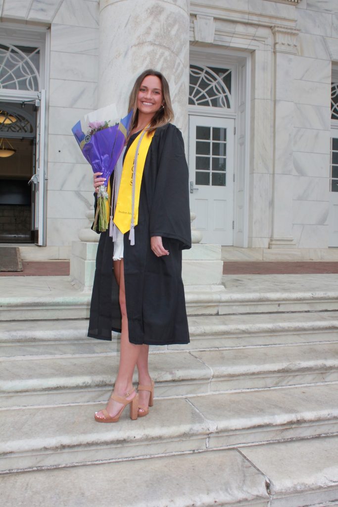 Bethany Sansone posing on Bunce Hall steps after graduation. 