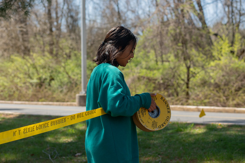 Forensic Anthropology classmate putting up caution tape to represent a real crime scene investigation.