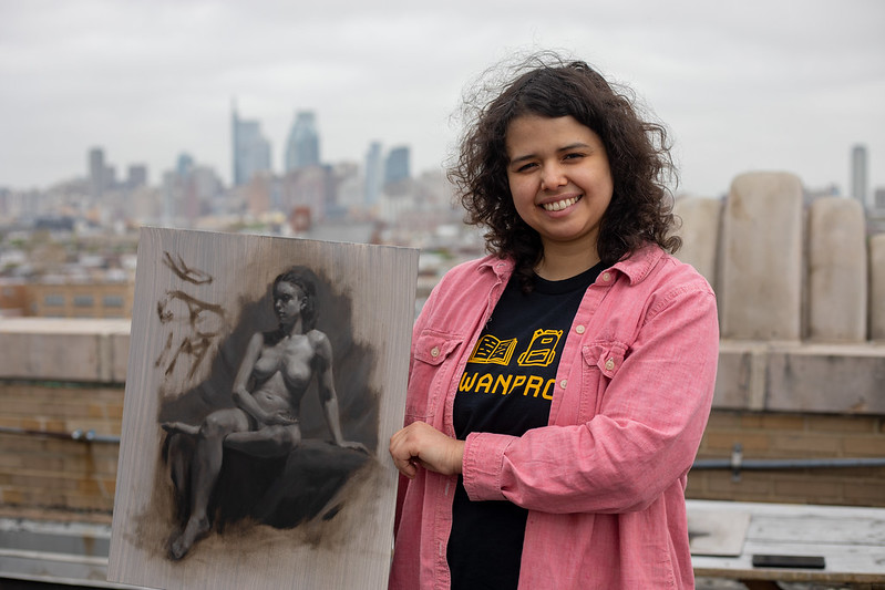 Hannah Healy holding up one of her original artworks.