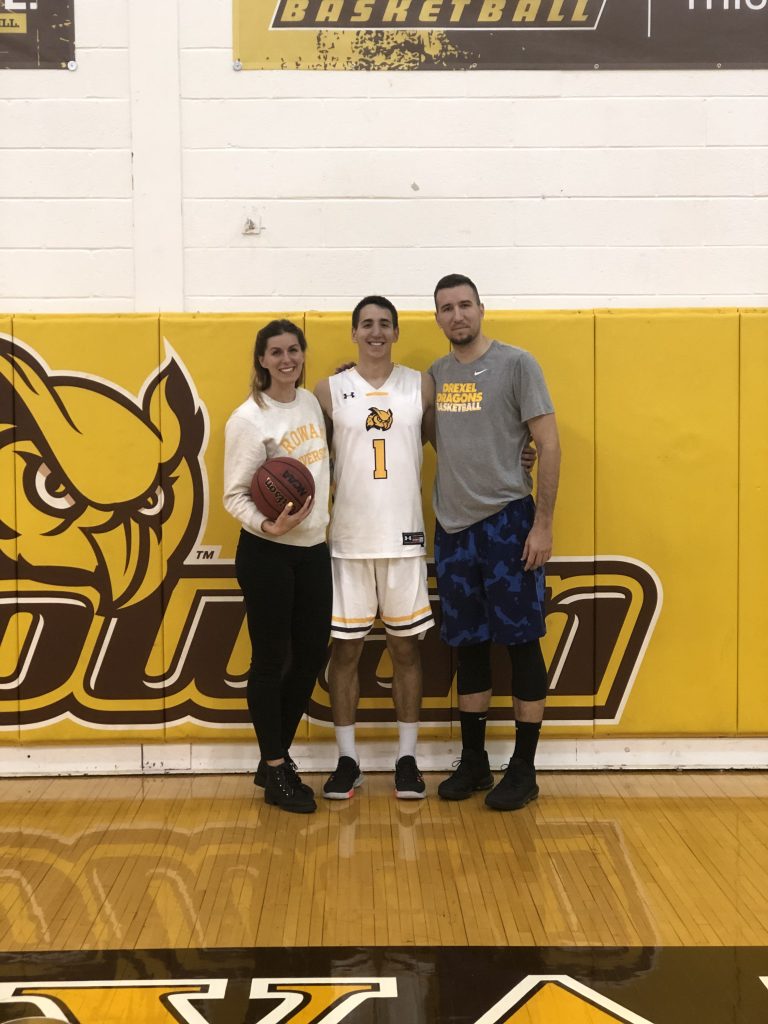 Marko poses with his brother and his brother's wife after a basketball game.