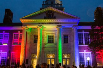 Exterior shot of Bunce Hall lit in Pride colors.