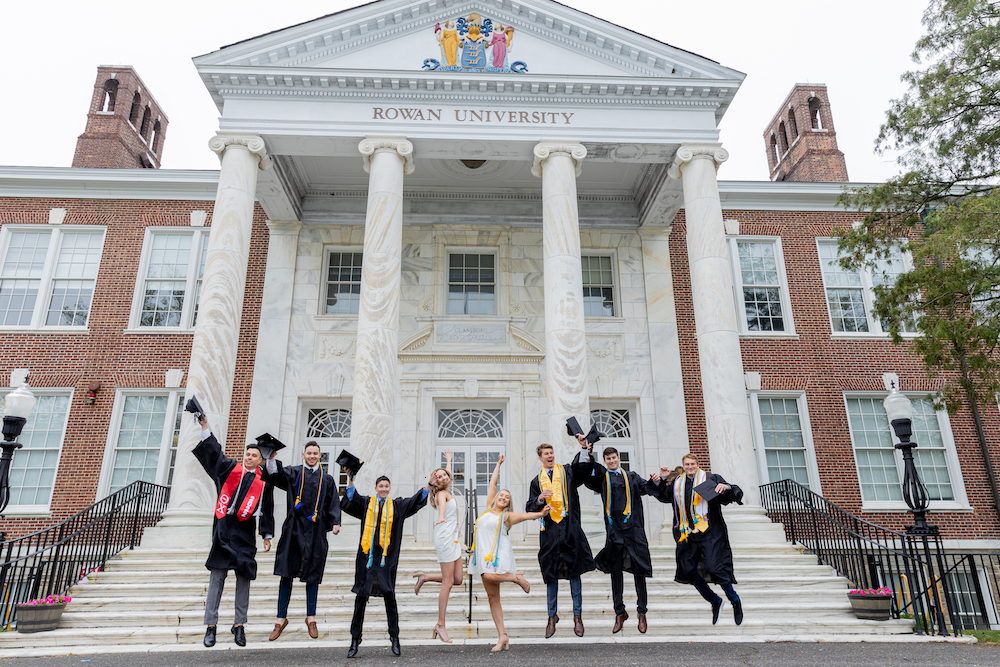 Matthew and friends celebrate and jump in front of Bunce Hall.
