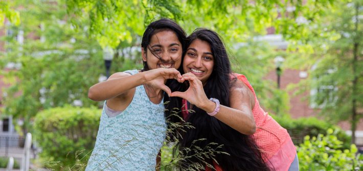 Two friends pose for Best Friends Day by joining their hands together to form a heart.