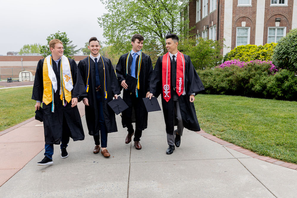 Matthew and friends walk past the side of Bunce Hall.
