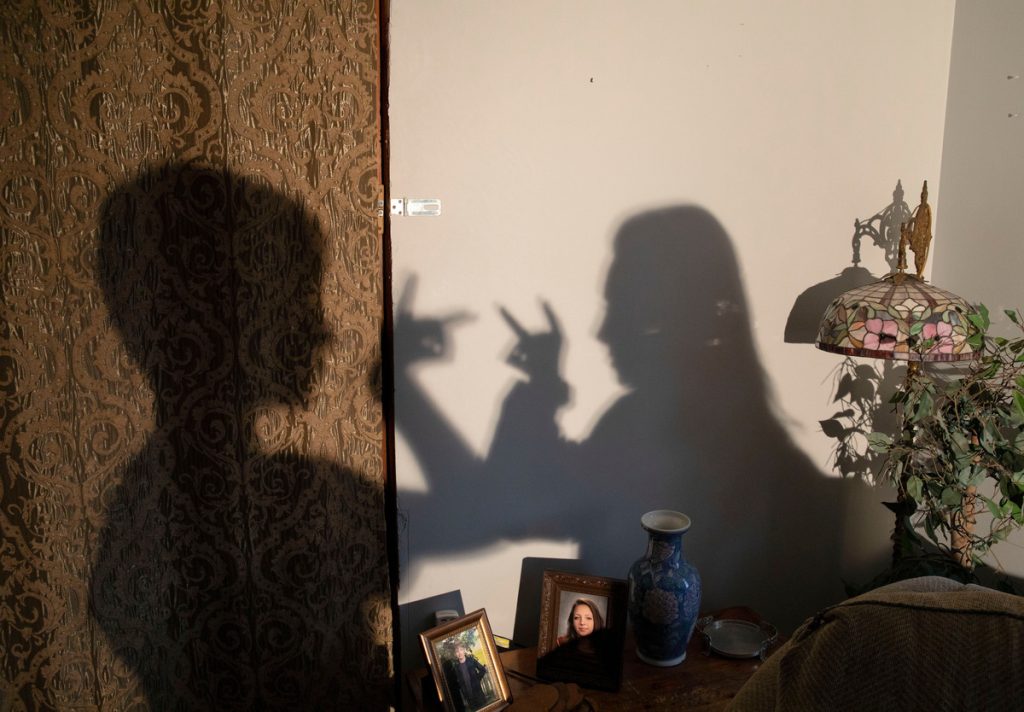 The shadows making shadow puppets of two people on a wall.