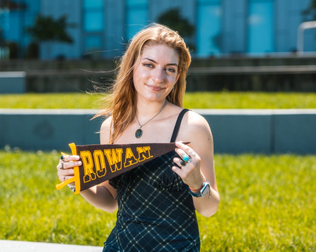 Author Skyla Everwine holds a Rowan University pennant.