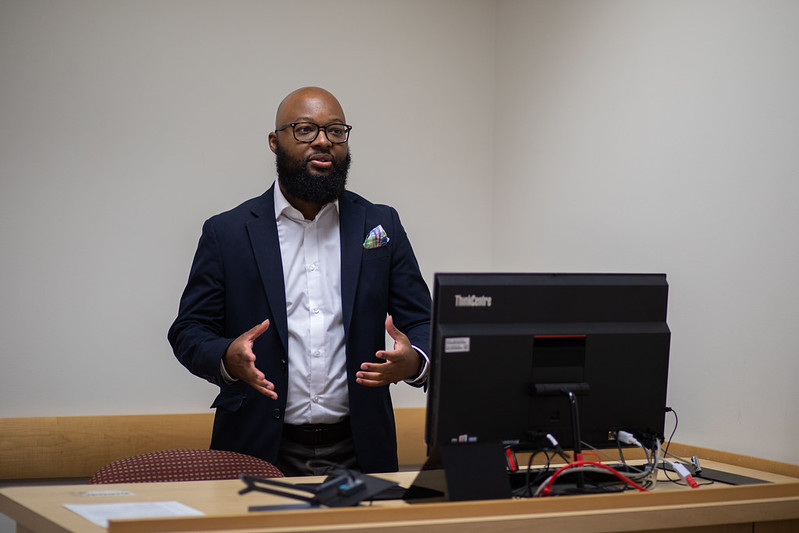 Dr. Adrian Barnes presents at a teacher's podium.