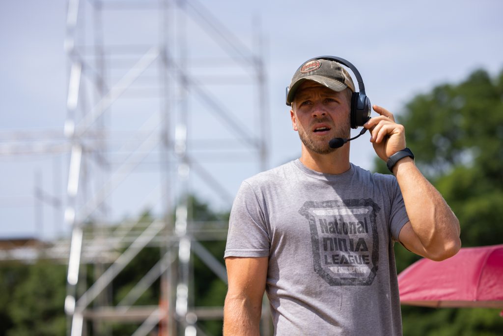 Chris wears a headset and works during a competition. 