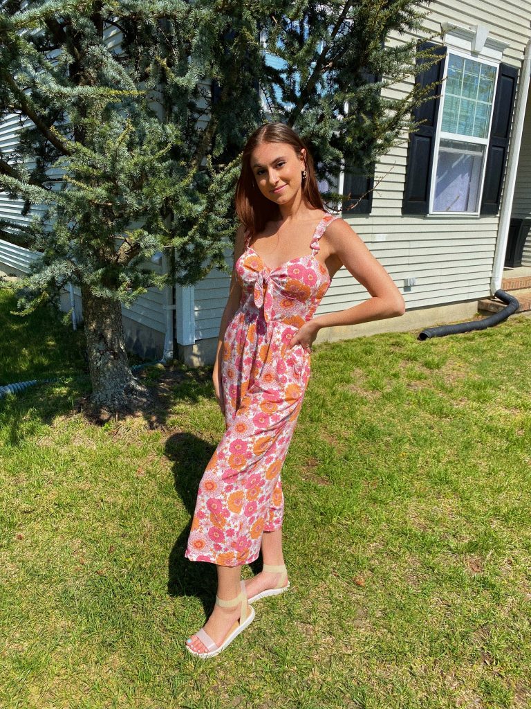 Katarina poses outside in a floral dress.