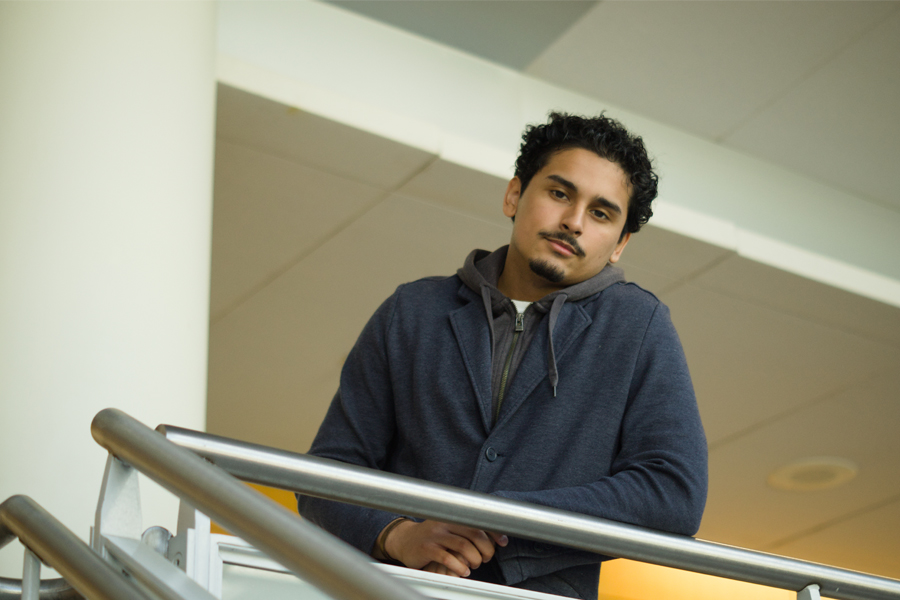 Esteban leans on a railing in Science Hall.