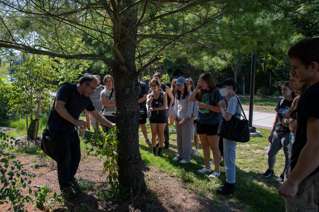 Dr. Duran shows students edible plant species off a walkway on Rowan University's campus.