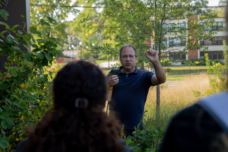 Dr. Daniel Duran shows students berries from a serviceberry or juneberry shrub located right outside Discovery Hall at Rowan University.
