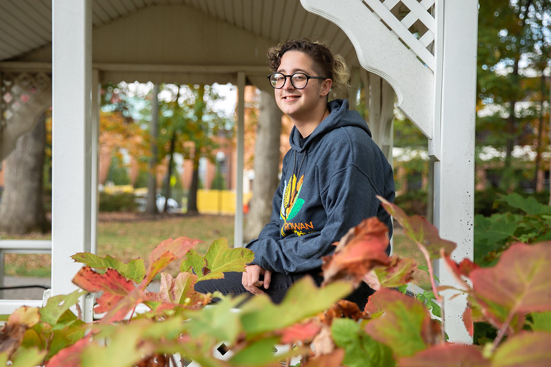 Rowan University Law and Justice major Kye in inside a gazebo with fall leaves in the foreground.