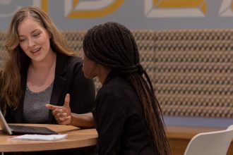 MBA/MSF accelerated student Kristin Carlson works with another student inside Business Hall.