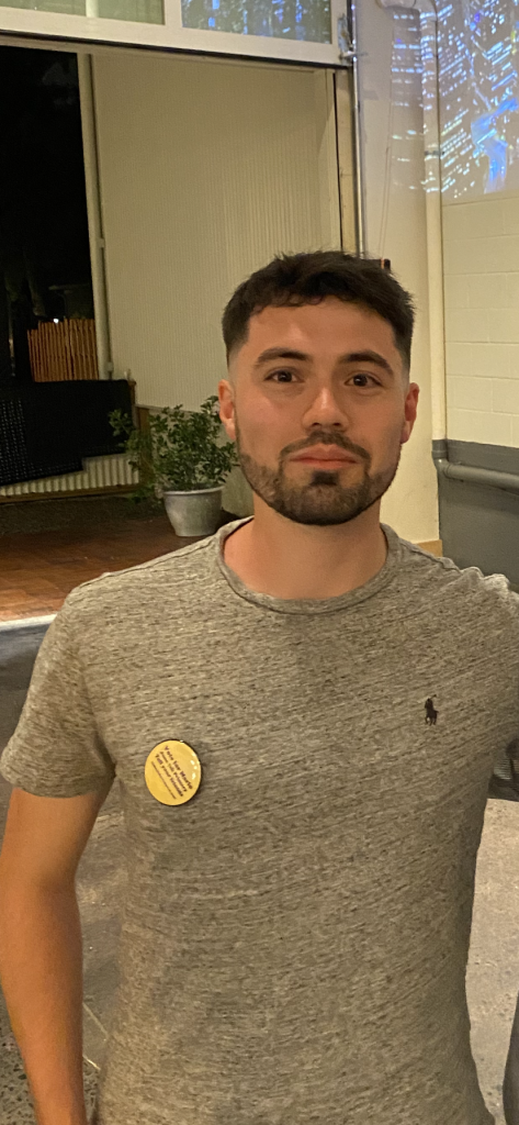 Kyle poses for a picture, wearing a pin.