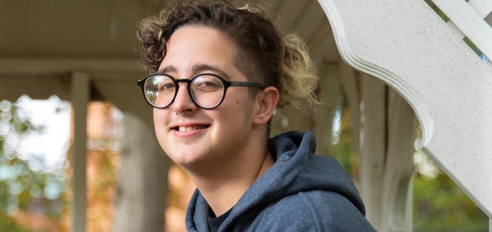 Rowan University Law and Justice major Kye inside a gazebo with fall leaves in the foreground.