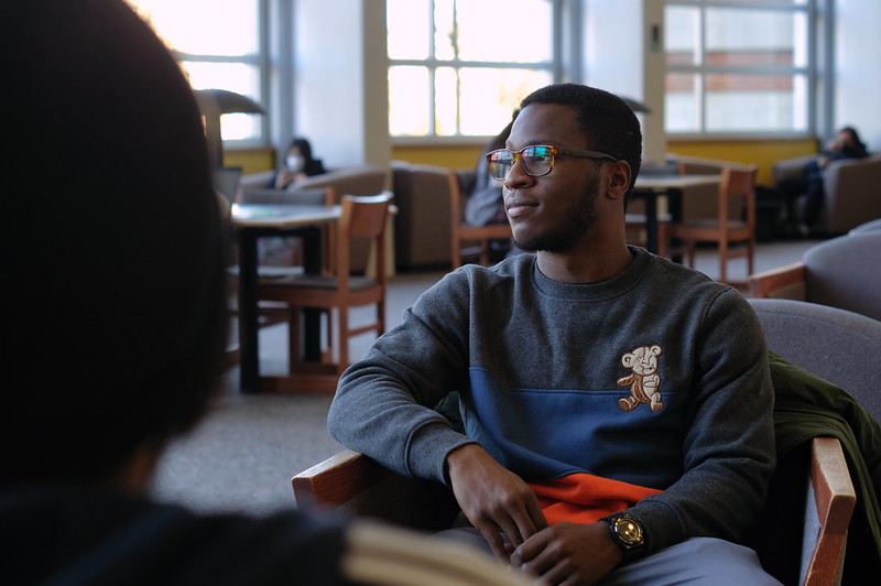 Accounting major Ezekiel looks away inside the Campbell Library seating area.