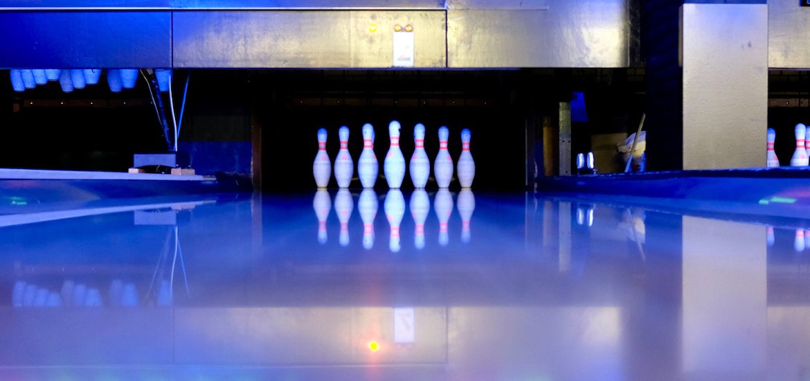 Stock image of the interior of a bowling alley with stacked pins.