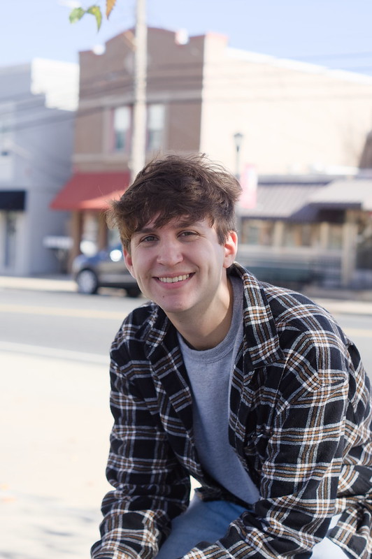 Jon smiles, sitting in Glassboro Town Square.