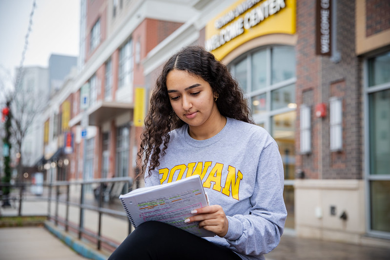 Biomedical Engineering major Miral reviews notes by the Welcome Center on Rowan Boulevard.