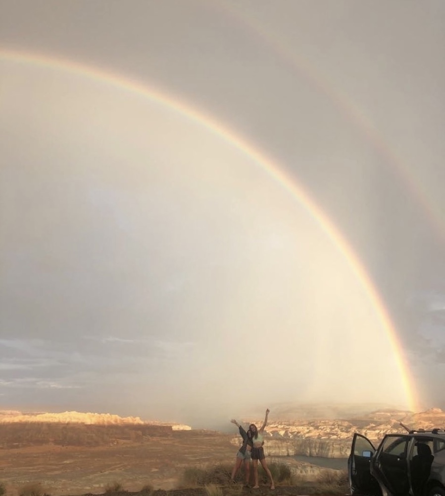 Rowan University Biological Sciences graduate Sofia stands beside a rainbow with a friend in Lake Powell. 