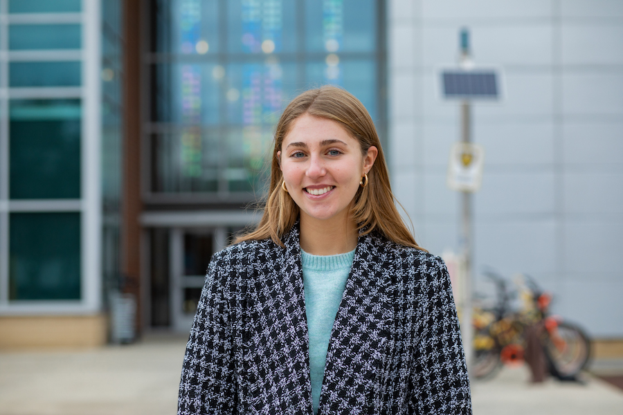 College of Education student Isabella smiles and stands outside James Hall. 