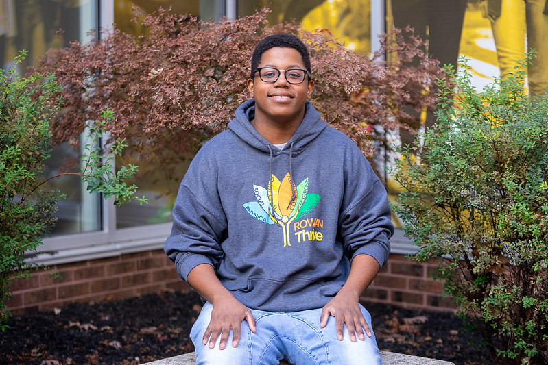 Rowan University Health and Science Communication major Sedrick smiles while standing outside the Wellness Center.