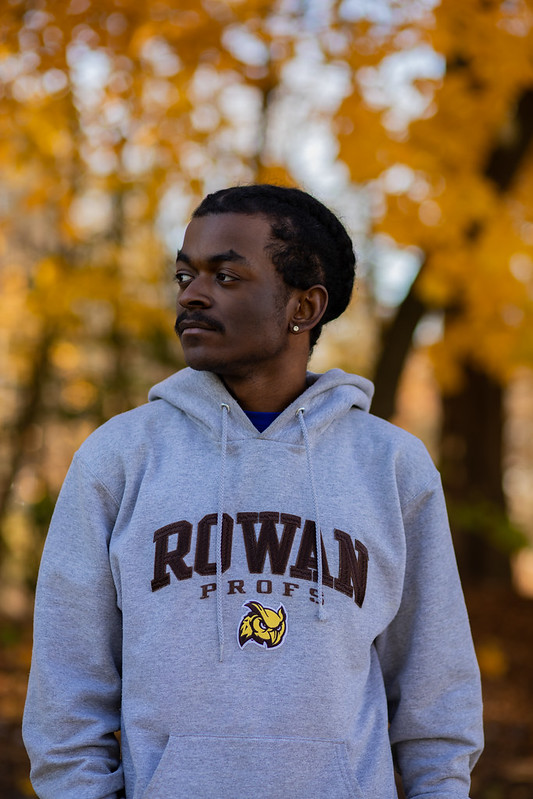Rowan University Law and Justice major Keshawn stands outside with fall leaves in the background.