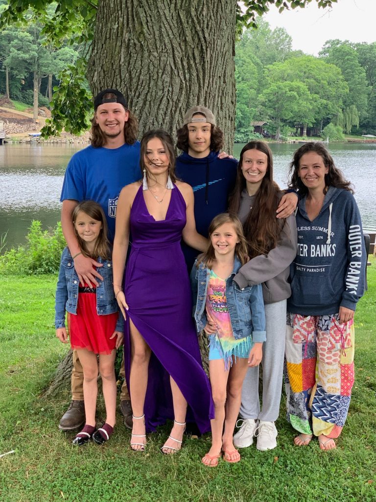 Kayla poses for a family photo with six of her family members.