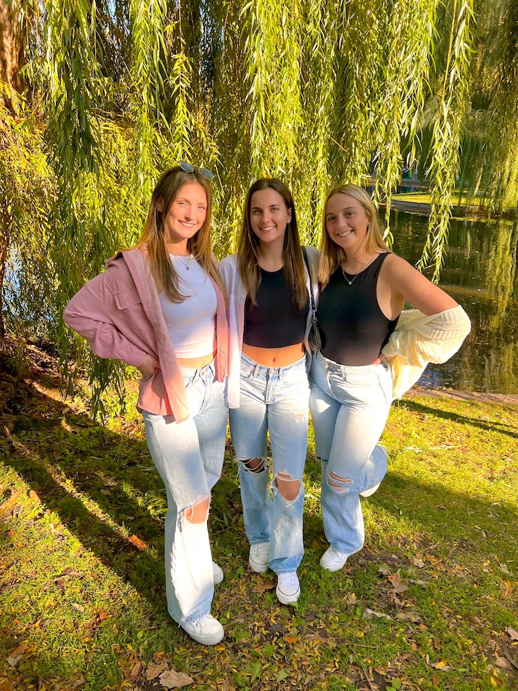 Rowan University Molecular and Cellular Biology major Lauren (left) poses with two friends in front of a weeping willow tree.