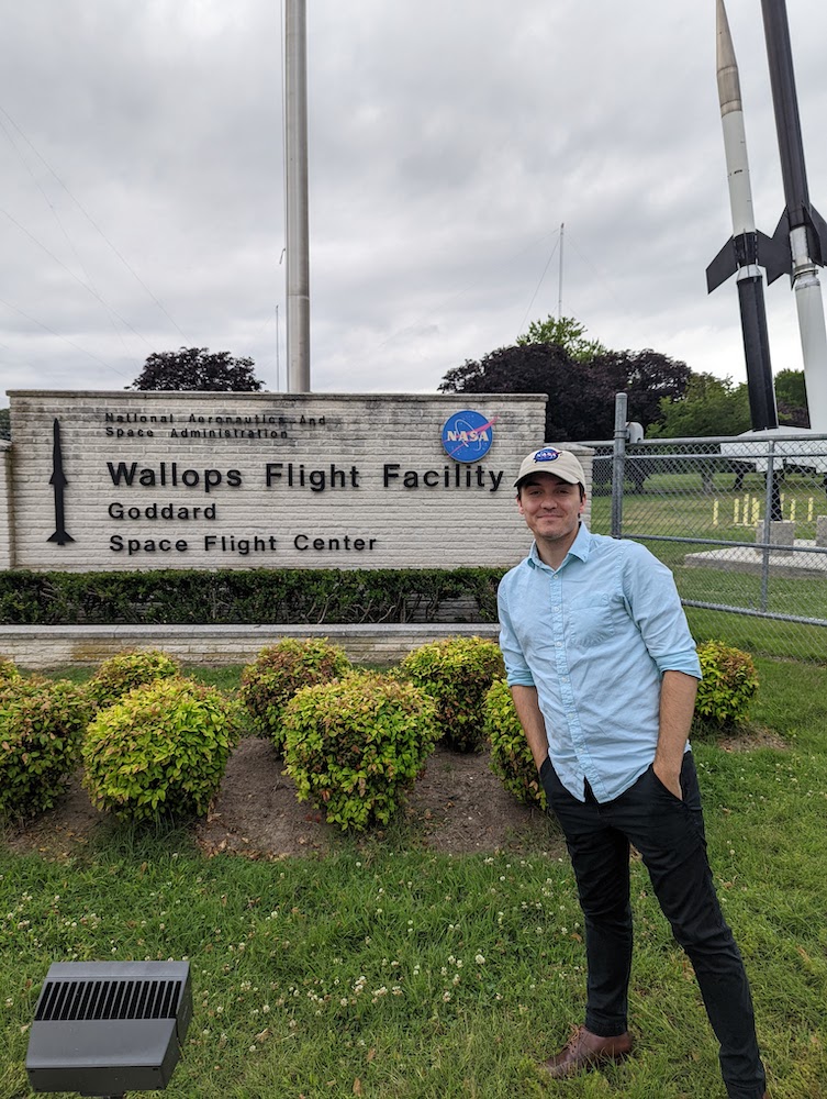 Rowan University Electrical and Computer Engineering major Benjamin Busler stands in front of the sign outside the Goddard Space Flight Center.
